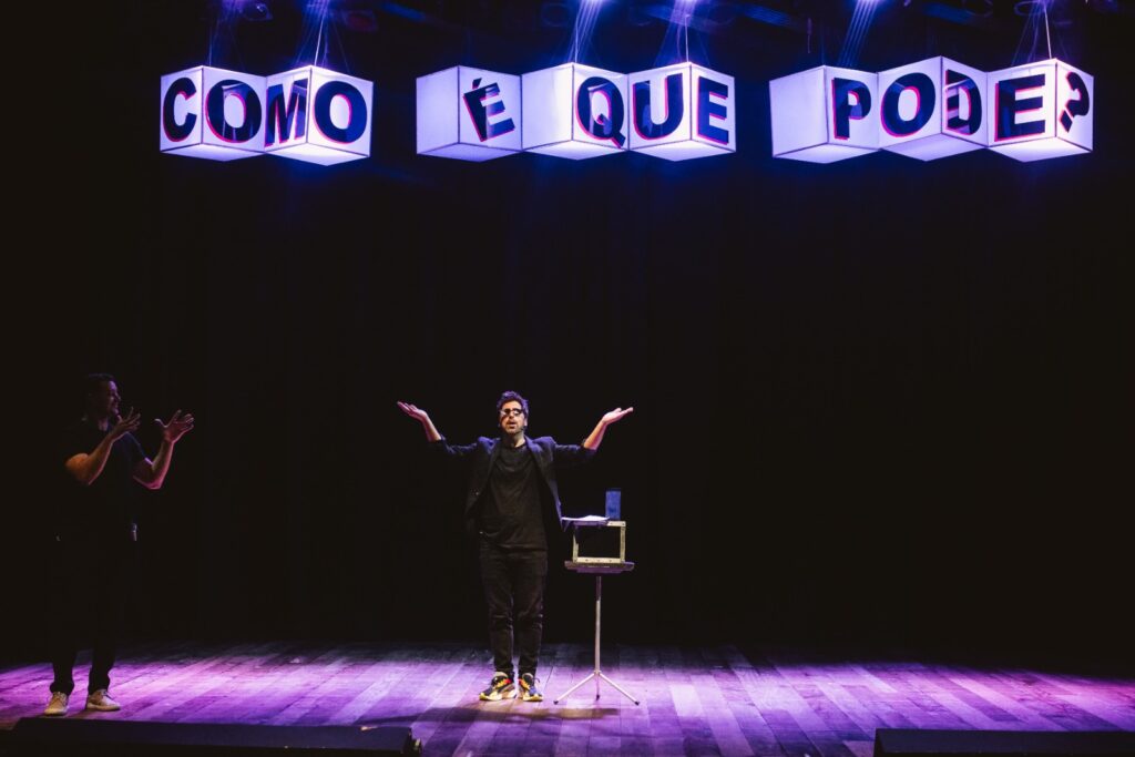 Gabriel Louchard apresenta o espetáculo Como é Que Pode em cima do palco de um teatro 