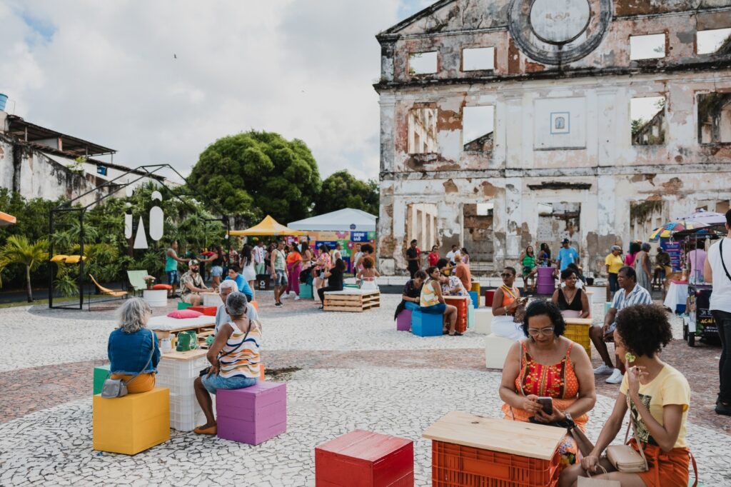 Público no espaço externo do Mercado Iaô em frente a casarão histórico na Ribeira Salvador