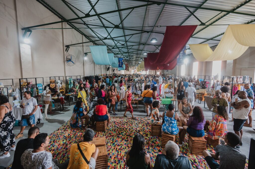 Mercado Iaô na Ribeira com público circulando entre barracas de empreendedores criativos em Salvador Bahia
