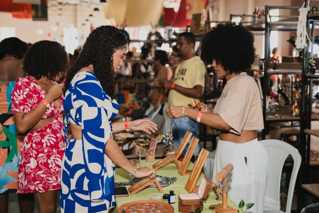 Visitantes conhecendo produtos artesanais em barraca do Mercado Iaô na Ribeira Salvador